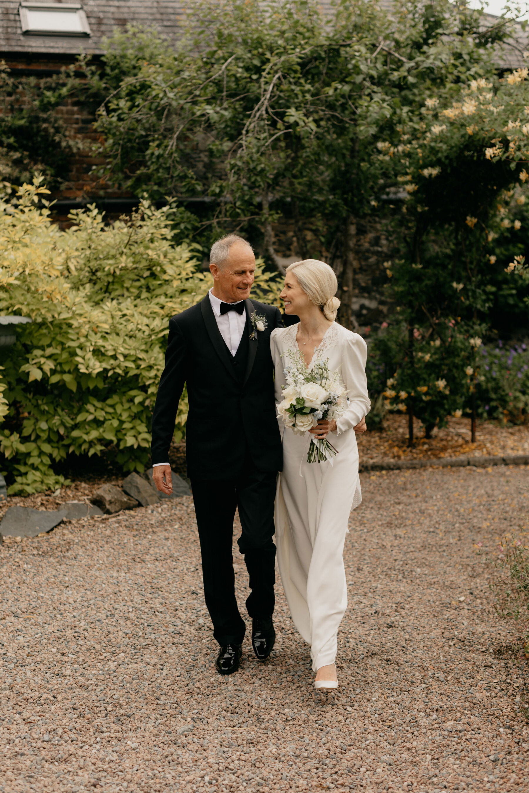 Father of the bride accompanying his daughter wearing a Rixo wedding dress. Larchfield Estate wedding, Northern Ireland.