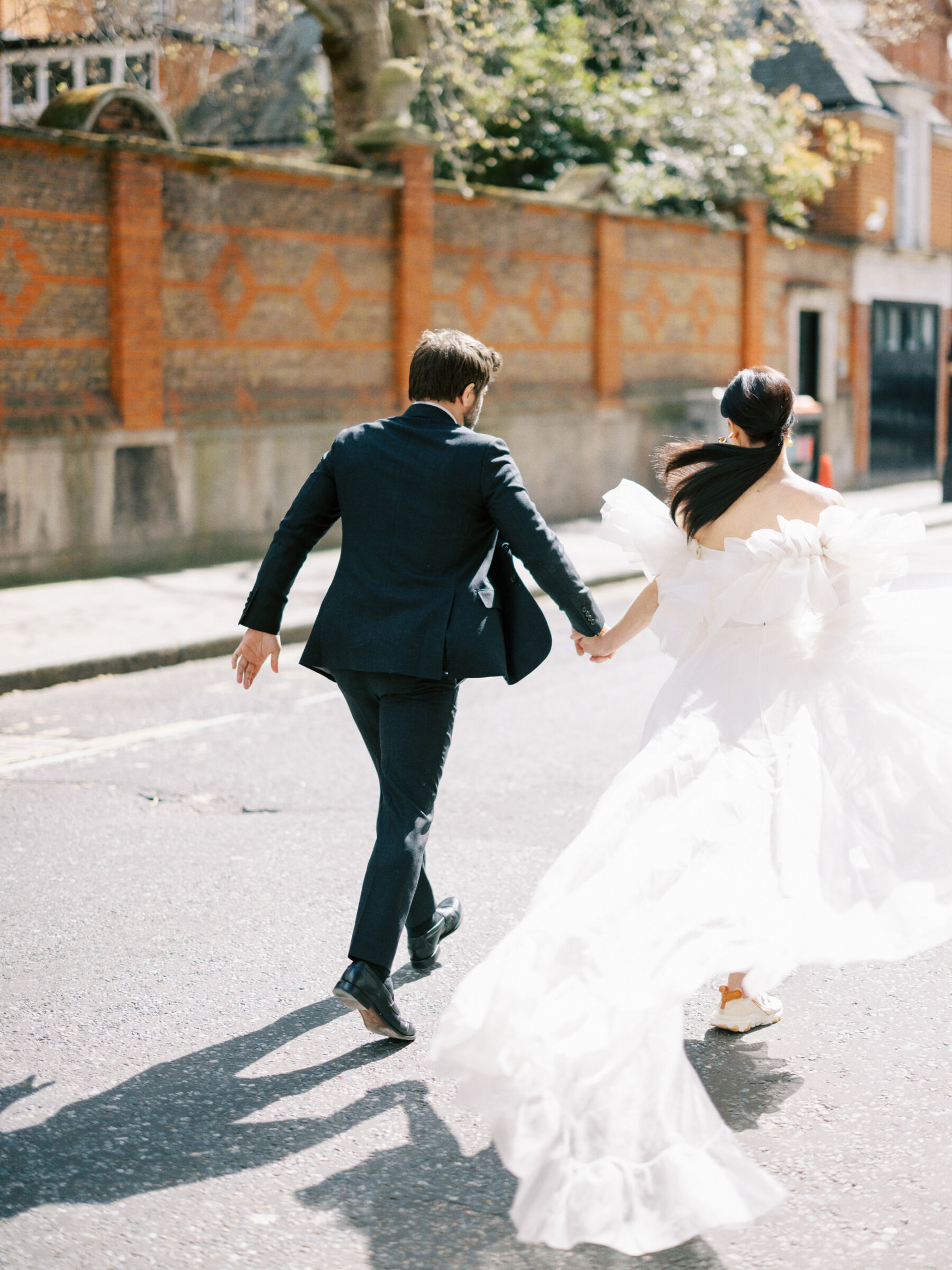 Modern bride wearing Halfpenny London with detachable puff sleeves running in trainers