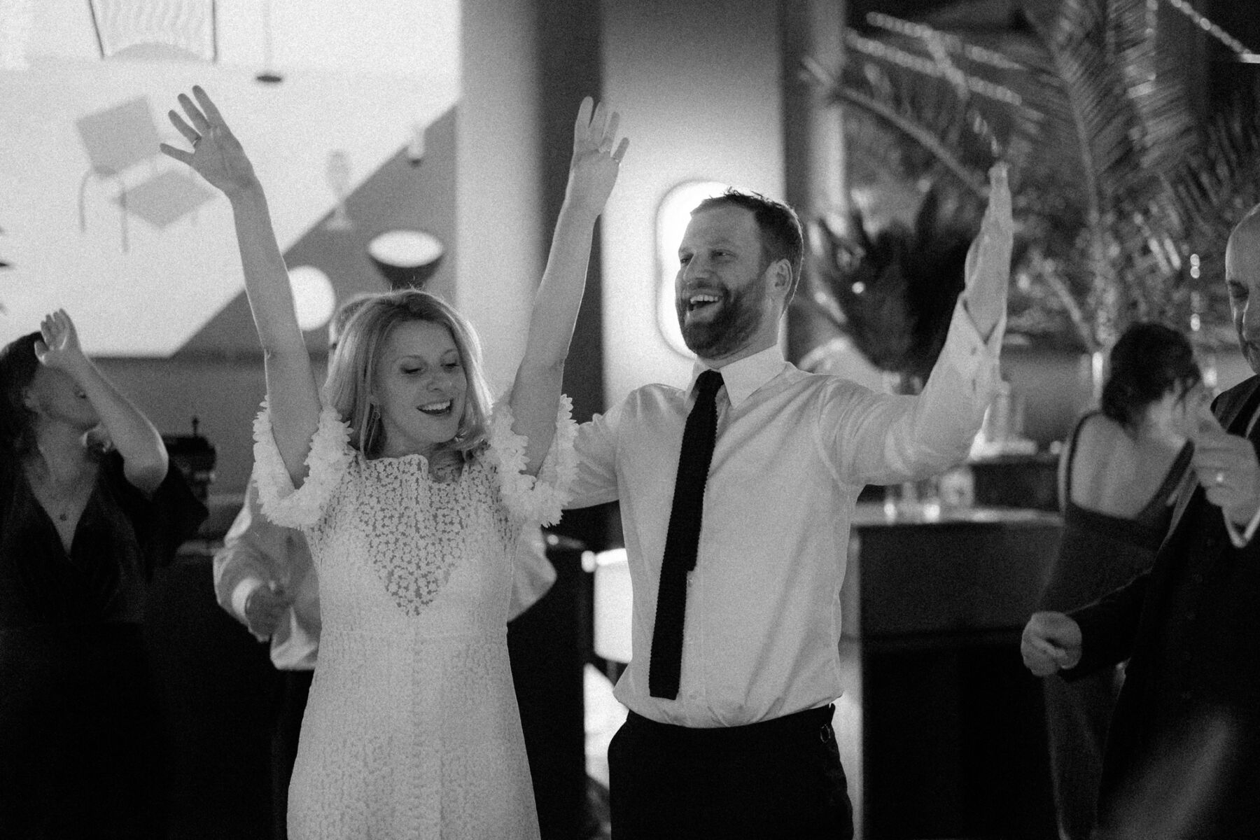Bride and groom raising their hands on the dancefloor. Rebecca Rees Photography.