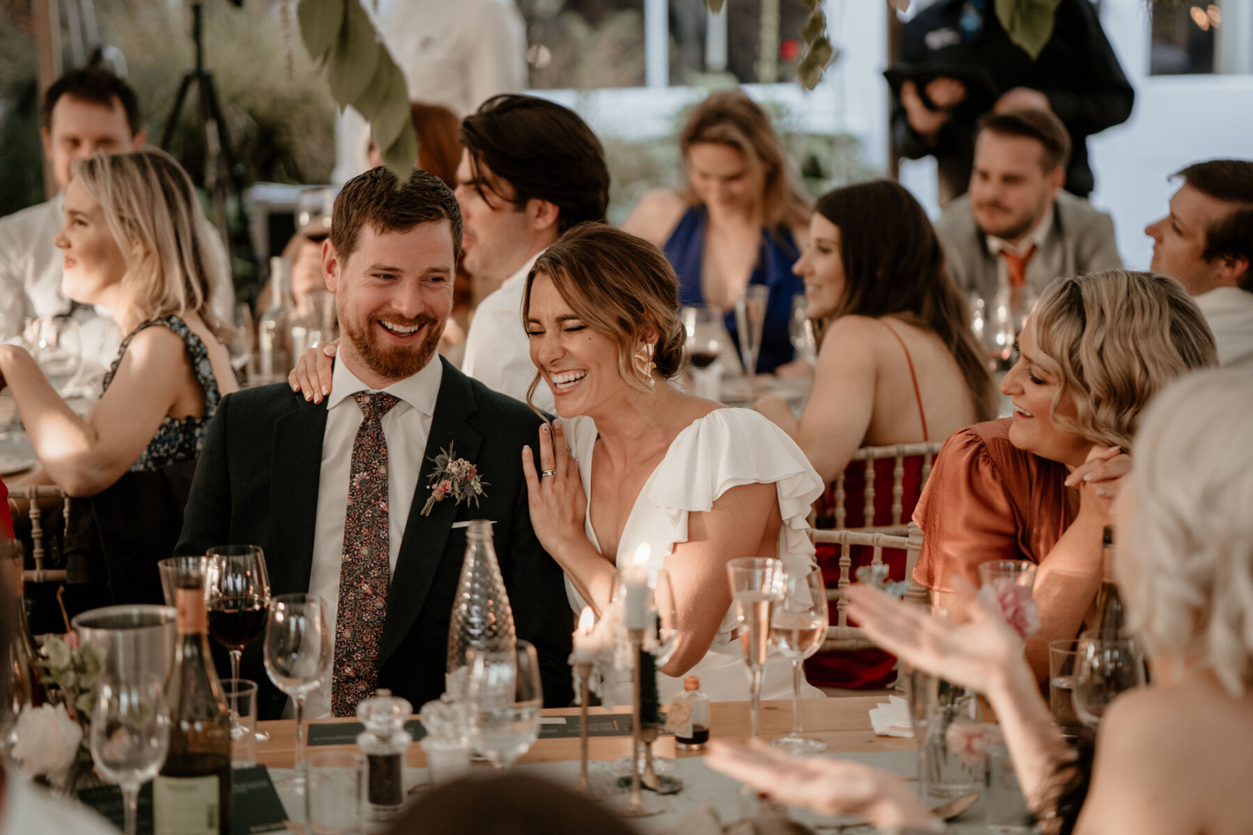 Bride and groom cuddling and laughing at their wedding reception