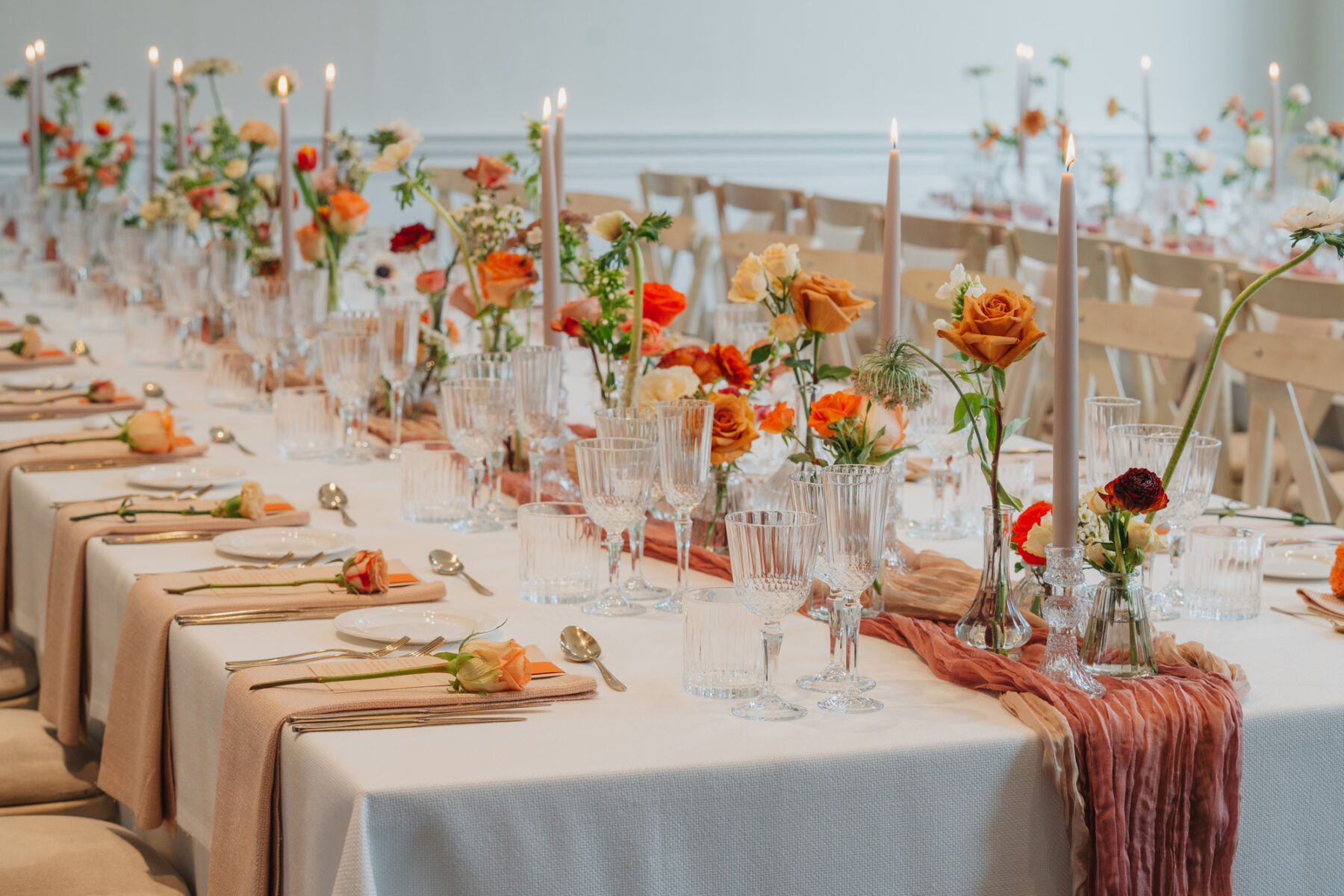 How to Create a Beautiful Sustainable Wedding on a Small Budget, with 41 Portland Place, London 20 Ribbed glasses and elegant taper candles. Hand dyed table runners in natural shades. Orange and cream roses.