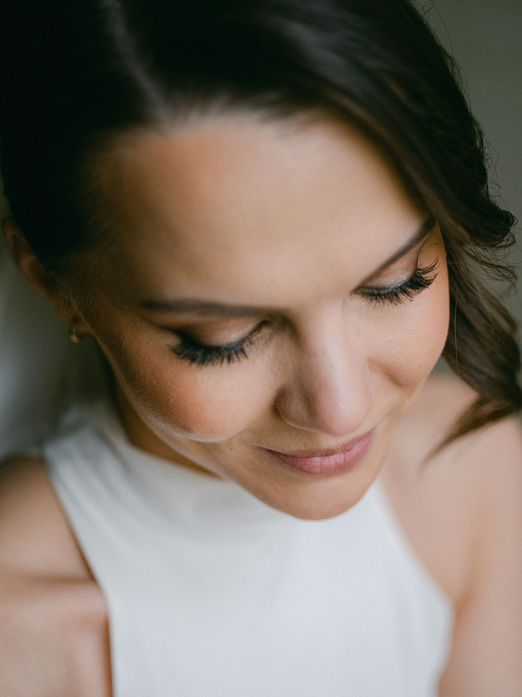 Celebrating Seasonal, British Grown Wedding Flowers With Flower & Fern at Findon Place 25 Portrait of a bride looking down to showcase her elegant wedding day makeup.