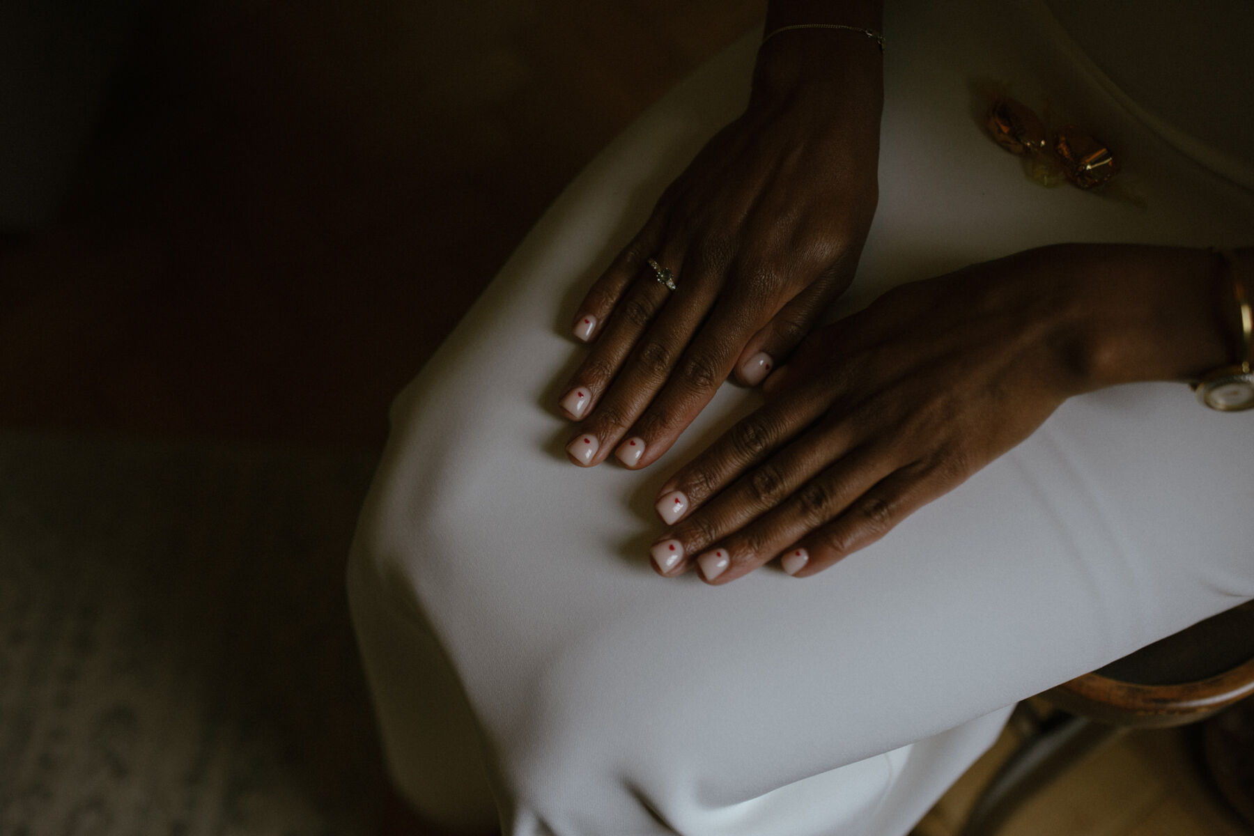Kim in Sarah Seven, for her Modern, Minimalist & Chic City Wedding, Captured by Ruth Atkinson 12 Close up shot of a Black bride's manicure - pale polish with tiny red hearts. Ruth Atkinson Photography.
