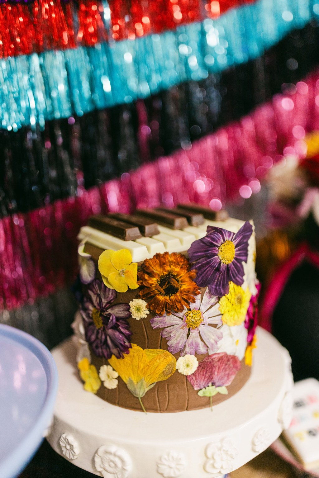 flower adorned cake with piano keys on top made of KitKat chocolates