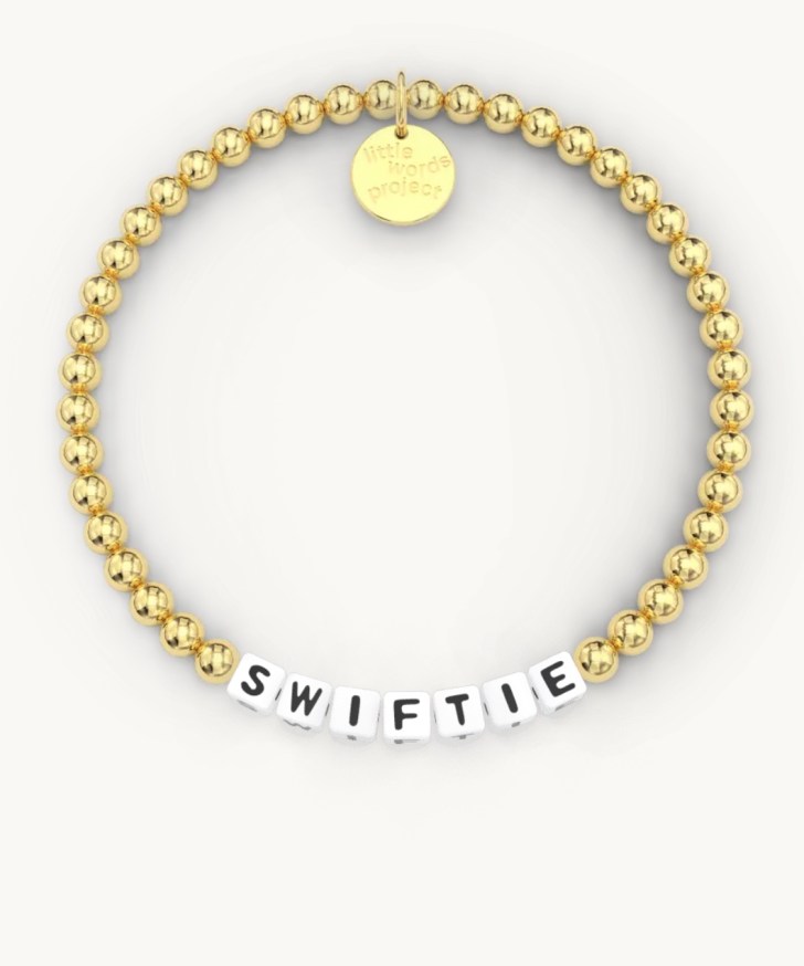 gold friendship bracelet best Taylor Swift gifts and ideas for fans with black and white beads that read "Swiftie"