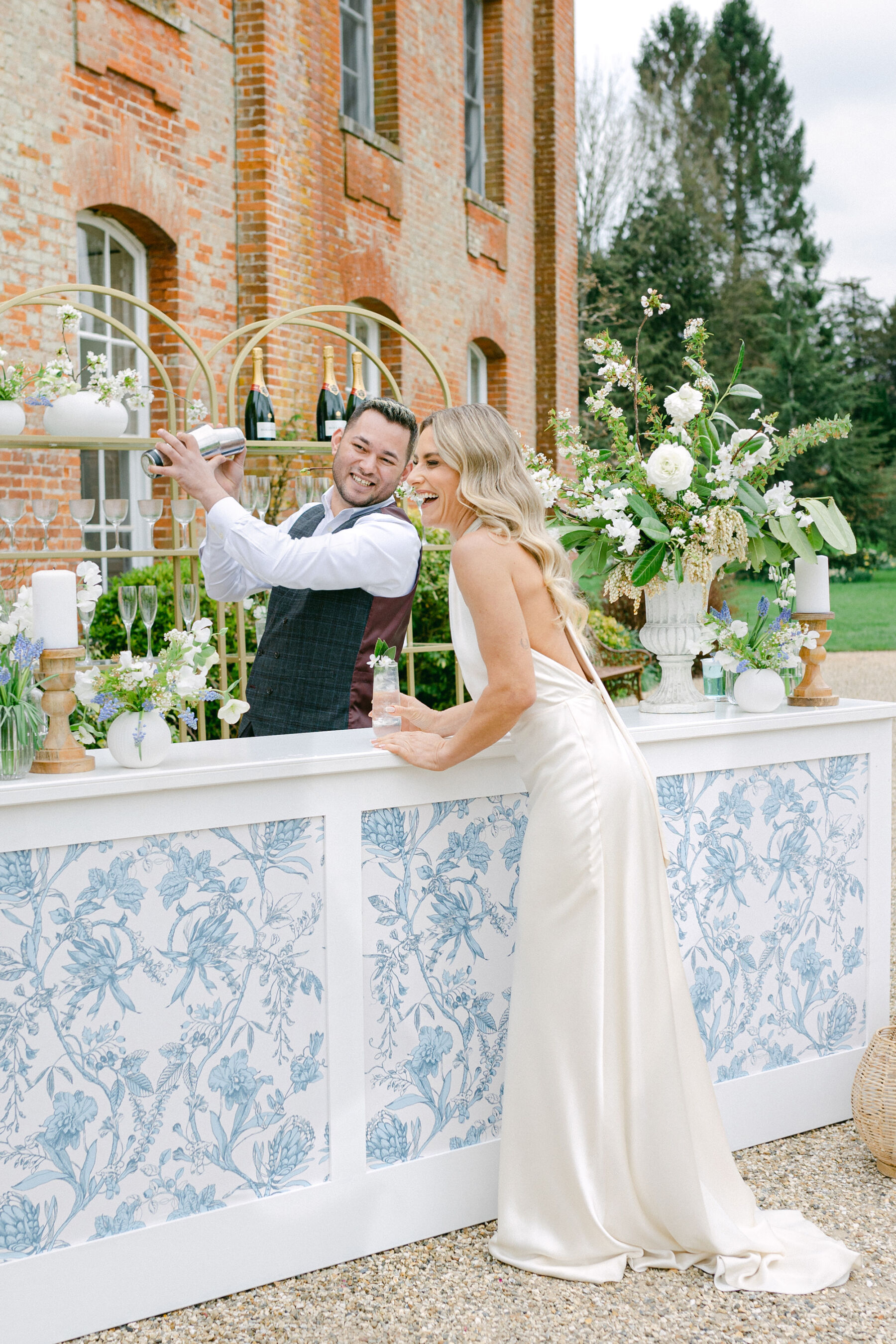 Pale Baby Blue Spring Wedding Inspiration at Avington Park, Featuring Halfpenny London 23 Elegant mobile wedding bar decorated with all white Spring flowers. Bride wears a silk halterneck wedding dress.