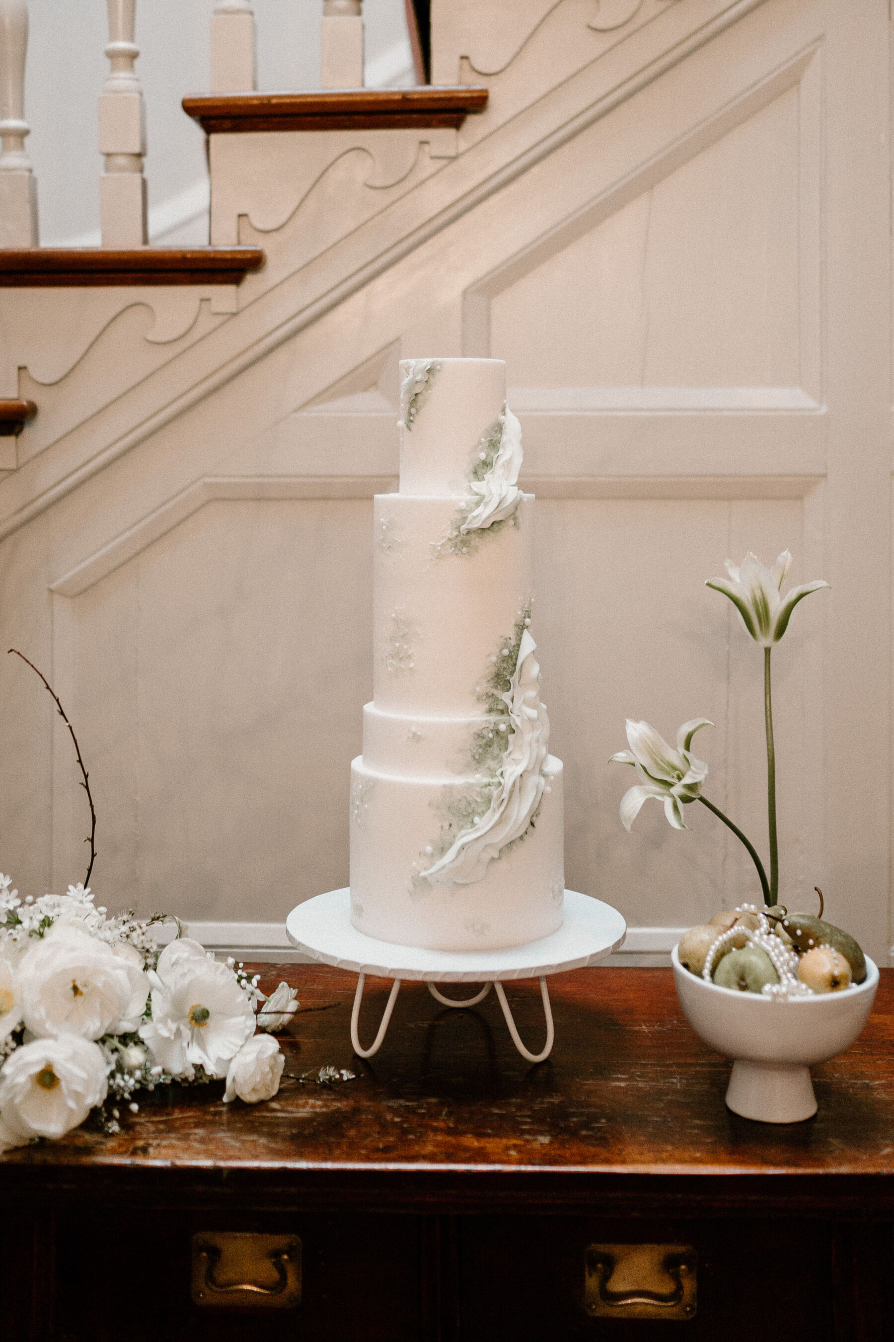 Tall, modern 3 tier wedding cake with elegant sage green icing.