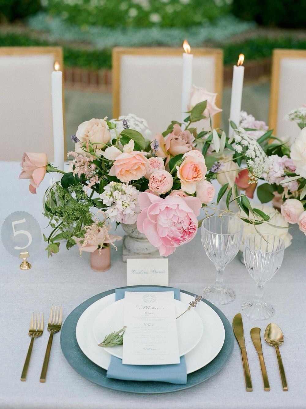 garden wedding place setting with pale blue linens and soft candlelight