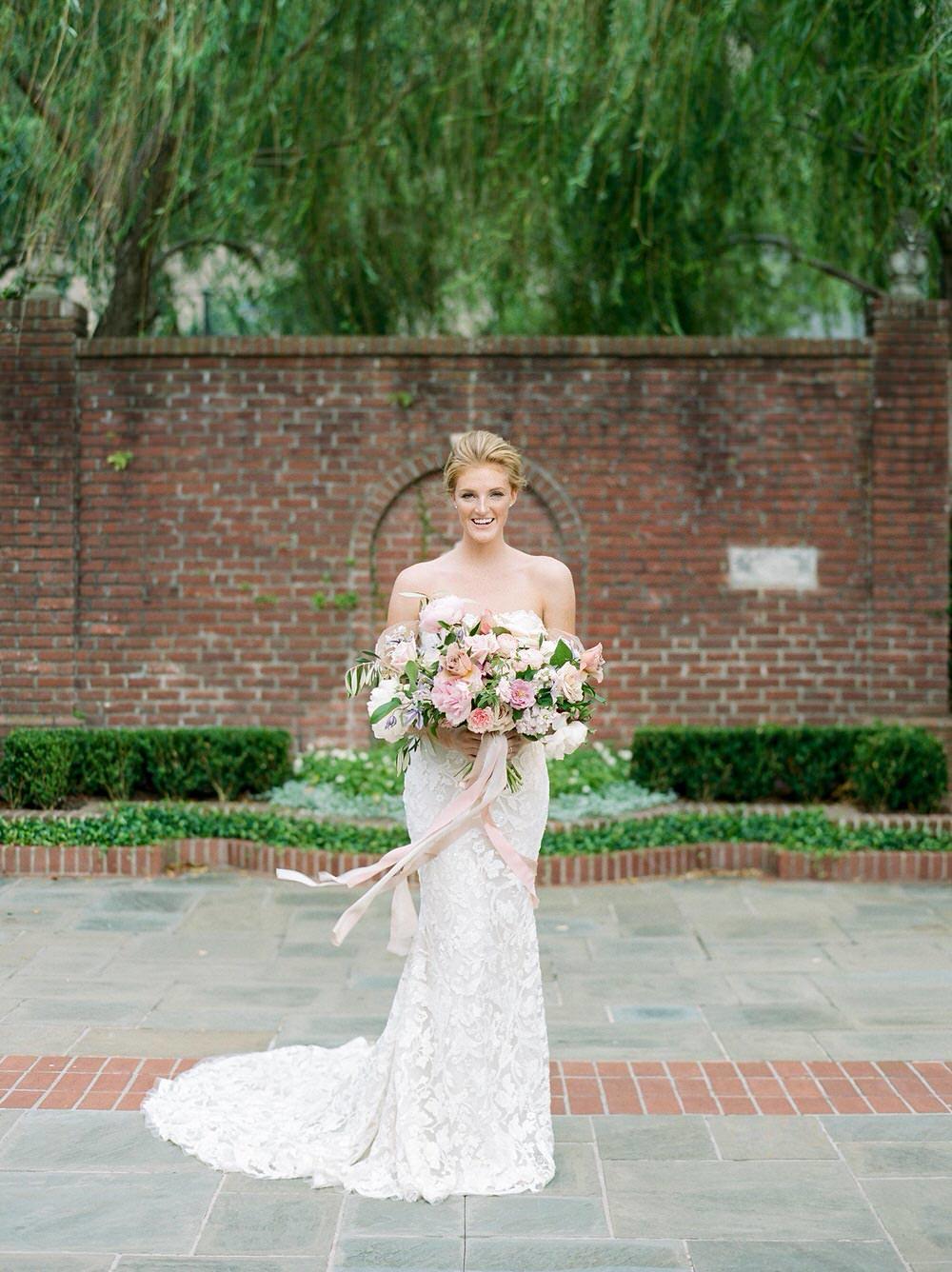 romantic bridal gown with soft off-the-shoulder sleeves and a garden flower bouquet