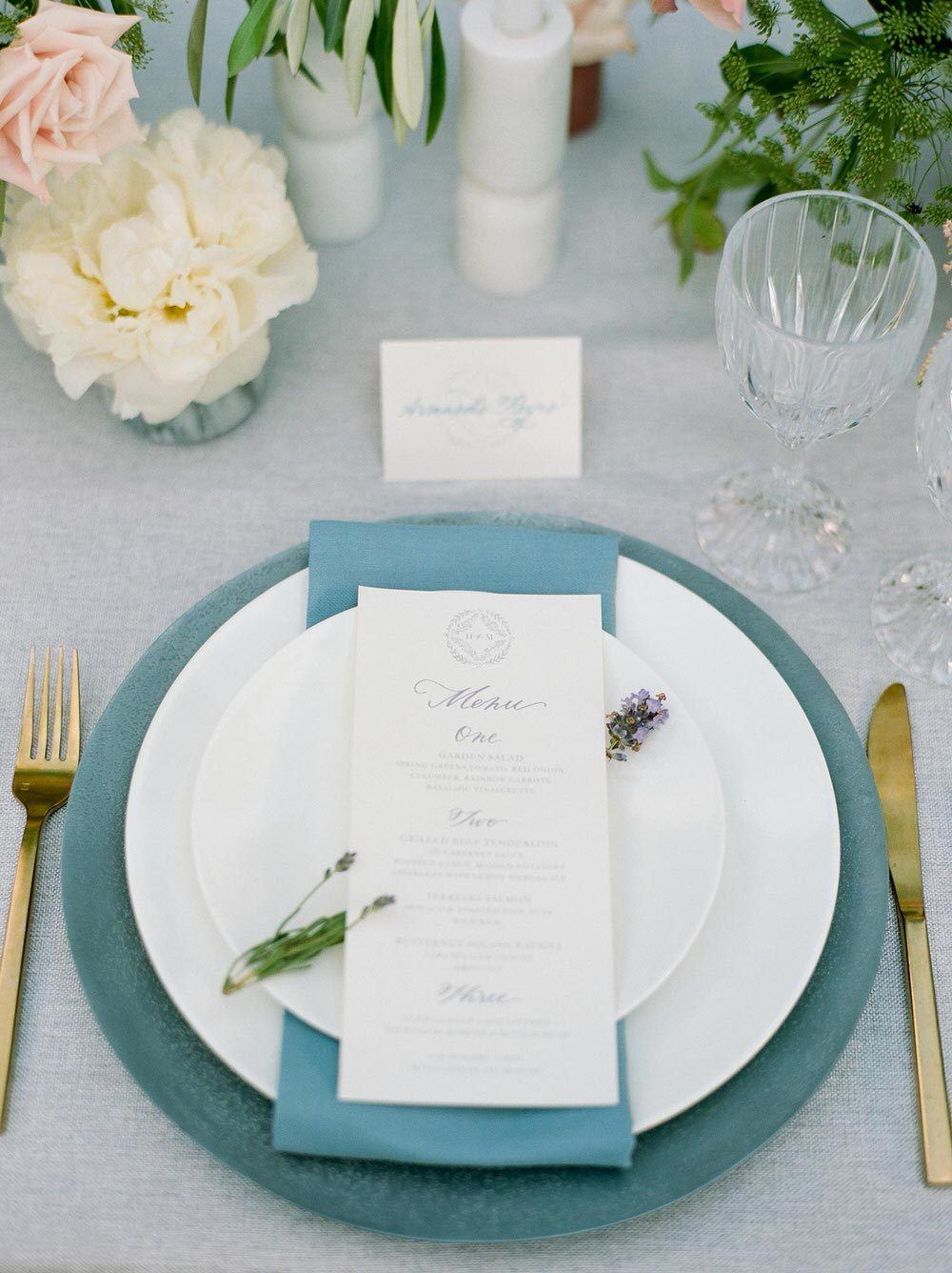 garden wedding place setting with pale blue linens and soft candlelight