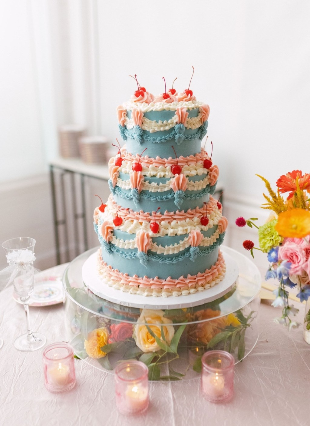 blue three-tier vintage wedding cake with white and pink frosting and cute cherries