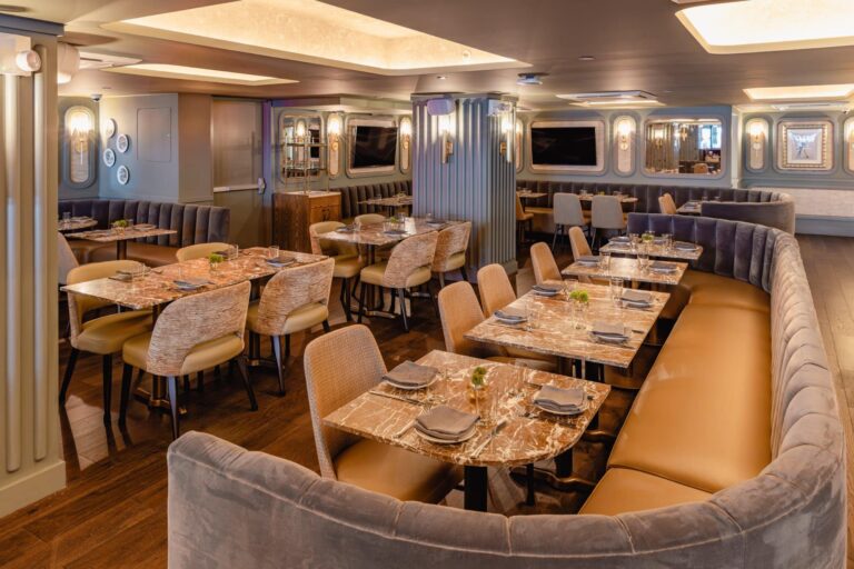 Elegant restaurant interior with marble tables and plush seating for special occasions.